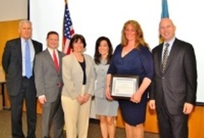 Photo of Penny Wood holding the award surrounded by Governor Jack Markell and others