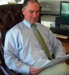 Photo of Todd Conner seated in a chair reading documents
