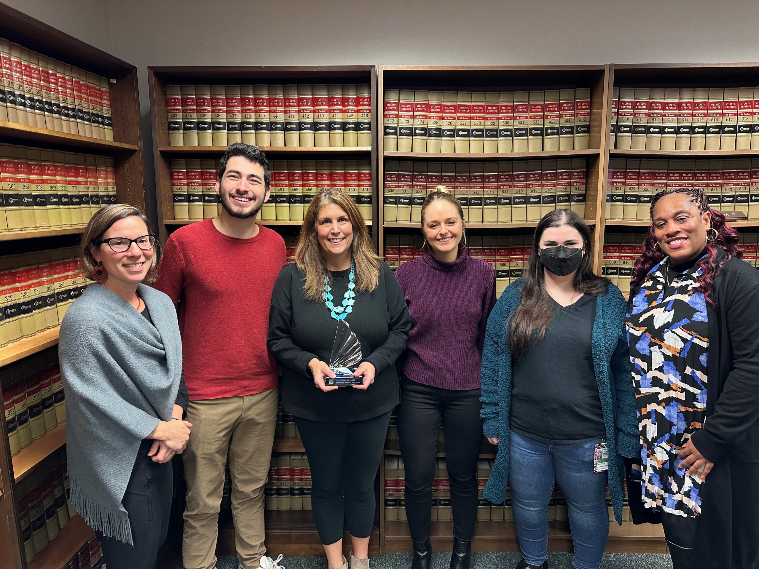 Dawn Williams, center, is awarded the Partners for Justice Legacy Award. From left to right is Eliza Hirst, ODS's post-disposition attorney, Ian Homsy, PFJ advocate, Dawn Williams, ODS Director of Training and Development, PFJ advocates Olivia Louthen and Susannah Gale, and PFJ Regional Program Director, Lenora Easter..